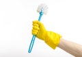 Cleaning the house and cleaning the toilet: human hand holding a blue toilet brush in yellow protective gloves isolated on a white Royalty Free Stock Photo