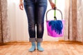 Cleaning the house with a lilac bucket, blue gloves, a mop and cleaning lady`s feet. Home cleaning concept