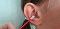 Cleaning and hygiene of child ear with cotton swab from contamination of eardrum and ear canal