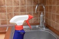 Cleaning kitchen sink and faucet with anti limescale spray, close up view Royalty Free Stock Photo