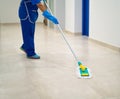 A cleaning lady cleans the hallway with a mop Royalty Free Stock Photo