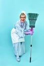 Cleaning Lady Fun. Elderly funny housewife fooling around with a broom. Full body blue isolated