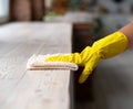 A Cleaning lady with gloves wipes dust from furniture with a cloth Royalty Free Stock Photo