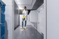 Cleaning lady mopping the floor in mens restroom Royalty Free Stock Photo