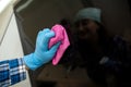 Cleaning lady's hands with a rag wiping the stove top and hood from greasy grease in kitchen. Royalty Free Stock Photo