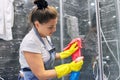 Cleaning lady woman washing glass of shower cabin in bathroom