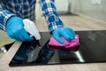 Cleaning lady& x27;s hands with a rag wiping the stove top and hood from greasy grease in kitchen. Royalty Free Stock Photo