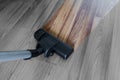 Cleaning laminate wood floor, vacuum cleaner cleaning dust and dirtiness Royalty Free Stock Photo
