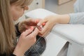 Cleaning and leveling the cuticle with nippers at the root of fingernails