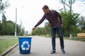 Cleaning man of an empty of plastic drinking bottle left on the road floor. Concept of environmental protection.