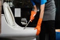 Cleaning online service. yong woman housekeeper cleaning flush toilet in bathroom with toilet brush. House cleaning Royalty Free Stock Photo