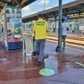 Cleaning operative cleaning the floor at a train station platform in Italy. August 2020.