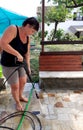 Woman Cleaning outside floor with water pressure cleaner Royalty Free Stock Photo