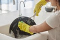 Cleaning pan, washing and hygiene hands with soap and water in the kitchen sink in home. Zoom of a female hand and Royalty Free Stock Photo