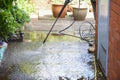 Cleaning patio paving with a high pressure washer the man is using the water to clean the garden path Royalty Free Stock Photo