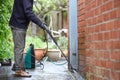 Cleaning patio paving with a high pressure washer the man is using the water to clean the garden path Royalty Free Stock Photo