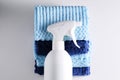 Cleaning product with a sprayer on a background of a blue microfiber cloth.