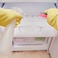 Cleaning the refrigerator freezer from dirt, a man hand in yellow gloves wipes kitchen appliances Royalty Free Stock Photo