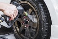 Cleaning and removing soap from the rim and tire of a car with a high pressure water spray gun Royalty Free Stock Photo