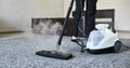 Cleaning service company employee removing dirt from carpet in flat with professional steam cleaner equipment close up Royalty Free Stock Photo