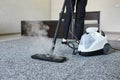 Cleaning service company employee removing dirt from carpet in flat with professional steam cleaner equipment close up Royalty Free Stock Photo