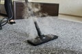 Cleaning service company employee removing dirt from carpet in flat with professional steam cleaner equipment close up Royalty Free Stock Photo