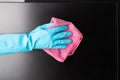 Cleaning service, disinfection, hand in glove wipes dust from a computer monitor or TV screen with a rag Royalty Free Stock Photo