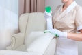 Cleaning service at the hotel. A girl in a cleaner`s uniform cleans upholstered furniture. Unrecognizable photo. The concept of Royalty Free Stock Photo