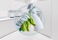 Cleaning service and products. Hands with gloves, green rag and spray bottle isolated on kitchen background, contacts housekeeping Royalty Free Stock Photo