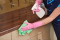 Cleaning service. wiping kitchen cabinet with cloth and liquid