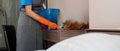 Cleaning service woman worker cleaning in bedroom at apartment. housekeeper cleaner feel happy and use feather duster Royalty Free Stock Photo