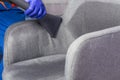 A cleaning service worker cleans the office chair with a washing vacuum cleaner