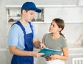 Cleaning service worker with documents communicates with client about services Royalty Free Stock Photo