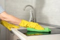 Cleaning service worker in rubber protective cleaning and polish electric cooker. Black shiny surface cooker and kitchen top, Royalty Free Stock Photo