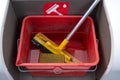 Cleaning set with squeegee, sponge and water for car windscreens in a red bucket at a gas station