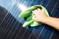 Cleaning solar panel with wipe. Hand wipes solar panels from dirt. Solar panel or photovoltaic module maintenance. Selective focus