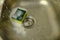 Cleaning sponge with foam on sink Royalty Free Stock Photo