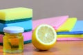 Cleaning sponge with scrub and rags set, olive oil, lemon on a wooden table. Eco house cleaning concept. Closeup Royalty Free Stock Photo