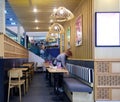 Cleaning staff takes care of tables after customers leaves a restaurant in shopping mall