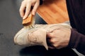 Cleaning suede sneakers. A worker in a shoe workshop cleans a pile of shoes Royalty Free Stock Photo