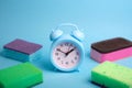 Cleaning supplies background, top view. Kitchen sponges, cellulose napkin rags, brush and alarm clock. Household chores Royalty Free Stock Photo