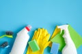 Cleaning supplies on blue background. House cleaning service and housekeeping concept. Top view spray bottle, sponge, rag, brushes