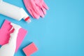 Cleaning supplies on blue background. Top view pink gloves, sponge, cleaner bottles. Cleaning services concept Royalty Free Stock Photo