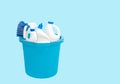 Cleaning supplies in blue bucket on pastel blue background Royalty Free Stock Photo