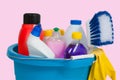 Cleaning supplies in blue bucket on pastel pink background Royalty Free Stock Photo