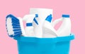 Cleaning supplies in blue bucket on pastel pink background Royalty Free Stock Photo