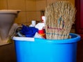 Cleaning supplies in blue plastic bucket close up shot at the entrance of a dirty bathroom Royalty Free Stock Photo