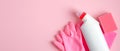 Cleaning supplies on pink background. House cleaning service and housekeeping concept. Top view spray bottle, sponge, rubber