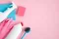 Cleaning supplies on pink background. Top view cleaner spray bottle, rag, sponge, detergent, brush, rubber gloves. House cleaning Royalty Free Stock Photo