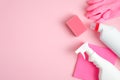 Cleaning supplies on pink background. Top view cleaner spray bottle, rag, sponge, detergent, rubber gloves. House cleaning service